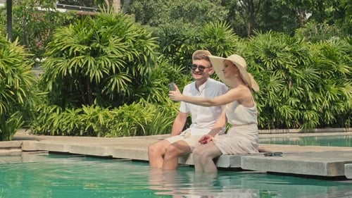 Couple Relaxing by Pool Taking Pictures on Vacation