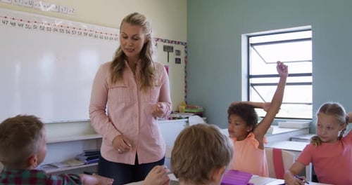 Teacher Instructing Young Students in a Classroom