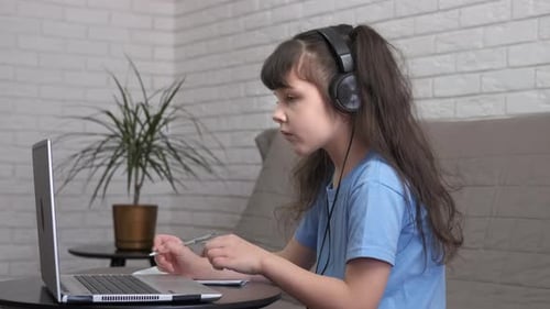Girl Studying at Laptop Wearing Headphones Indoors