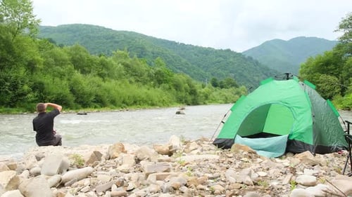 Budget Tourist Resting By the Mountain River He Set Up a Green Tent for the Night
