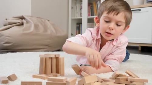 Young Boy Plays with Blocks on Floor