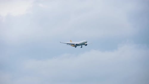Airplane Descending in Cloudy Sky
