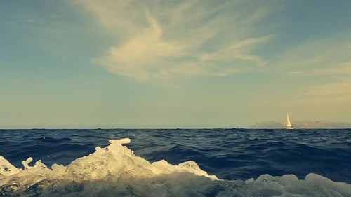 Niedrigwinkel-Wasseroberflächenansicht eines Segelboots, das auf Meerwasser navigiert, von einem anderen Kreuzfahrtschiff aus gesehen