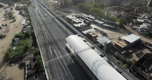 Suburban Train Departing From the Station in Industrial City Area, Aerial