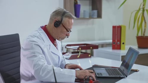 Arzt schreibt während eines Videoanrufs einen Termin für einen Kunden