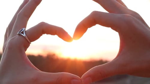 Hands Make Heart Shape During Sunset