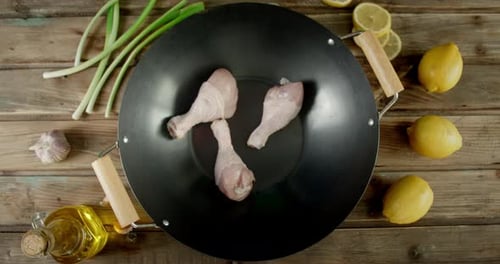 Raw Chicken Drumsticks Placed in a Wok