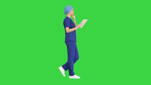 Young Woman Doctor Nurse Scrubs Using Touchscreen Computer While Walking Green Screen Chroma Key