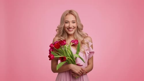 Blond Woman Smiling with Red Tulips Bouquet