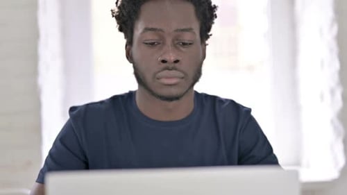 Close Up of African Man Using Laptop in Modern Office