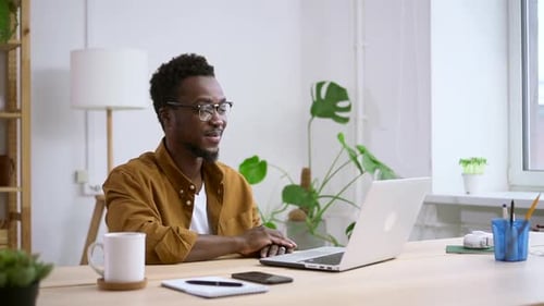 Young Man Video Conferencing at Bright Desk