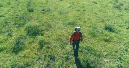 Flight Over Backpack Hiking Tourist Walking Across Green Mountain Field