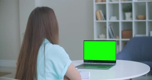 Woman Sits at Desk in Bedroom, She Looks at Laptop Green Screen and Talks To Someone Over Internet
