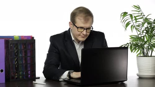 Businessman Working in Office. Opens a Laptop and Starts Working with Interest