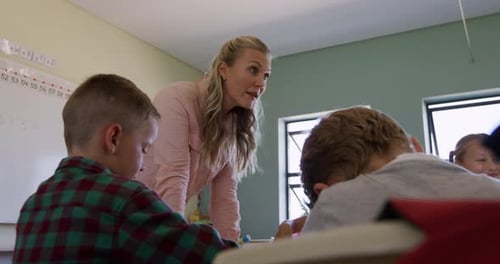 Female Teacher Helping Students in Classroom