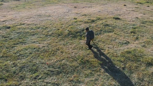 A Trained Dog Clenched Teeth on Trainer Arm and They Spinning Around on the Field