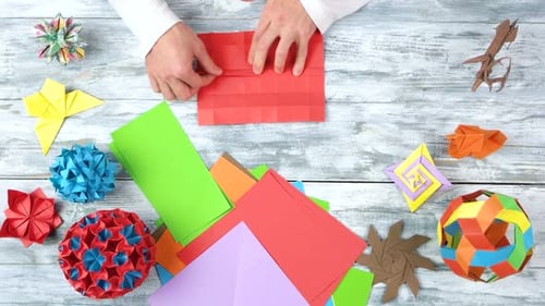 Männliche Person, die Origami-Objekt erstellt