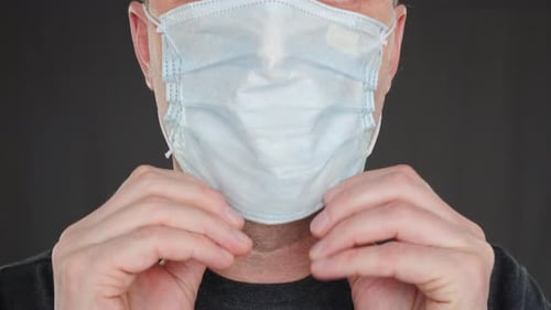 Close Up Adult Man Putting on Face Mask Front Camera. Male Face Wearing Protective Mask. Protection