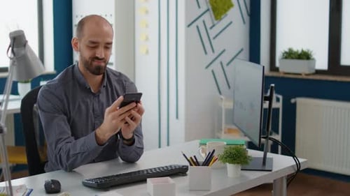 Office Worker Using Smartphone to Browse Internet and Text Messages