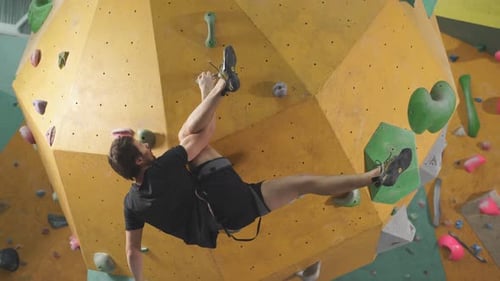 Strong Man Practicing Climbing on Artificial Rock Wall