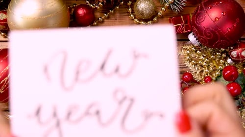 Hands Place New Year Card Amongst Ornaments