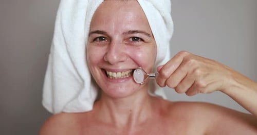 Woman Using Facial Roller for Beauty Treatment