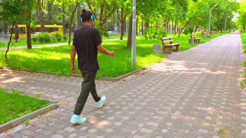 Guy with Headphones Listening Music in City