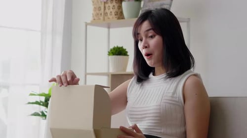 Excited Woman Opens Package at Home