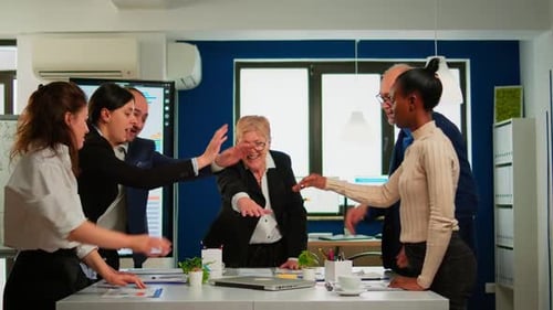 Motivated Business Team Puts Hands Together in Office