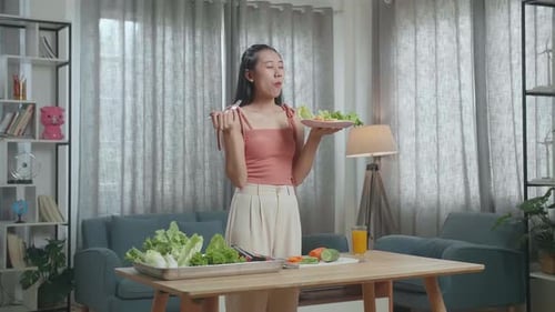 Young Woman Enjoys Eating a Salad at Home