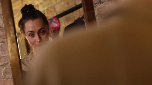 Mulher experimentando um vestido preto na frente do espelho