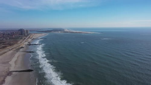 A high angle view of an empty beach on a beautiful day with a few clouds. The camera dolly in over t
