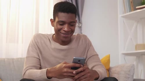 Man Using Smartphone While Sitting On Sofa