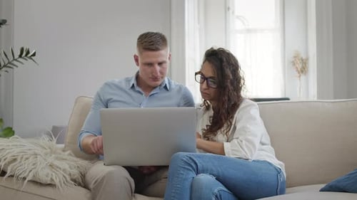 Young Couple Using Laptop Together on Couch