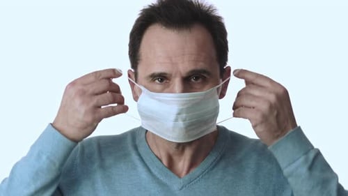 Man Puts on a Surgical Mask for Protection