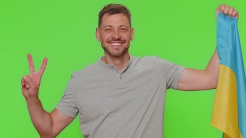 Man Smiling and Holding Ukrainian Flag on Green Screen