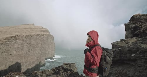 Man looks around on mountain top