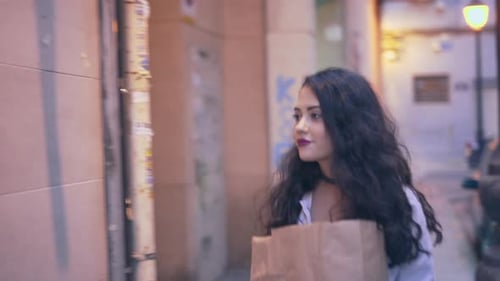 Woman Walks Down City Street at Night