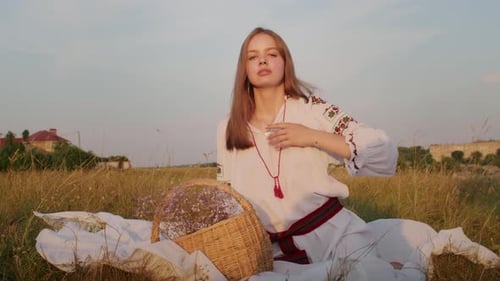 Young Woman Posing in Grassy Field at Sunset