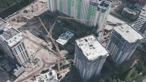 Hochkrane auf der Baustelle mit Wolkenkratzern. Bau moderner Mehrfamilienhäuser