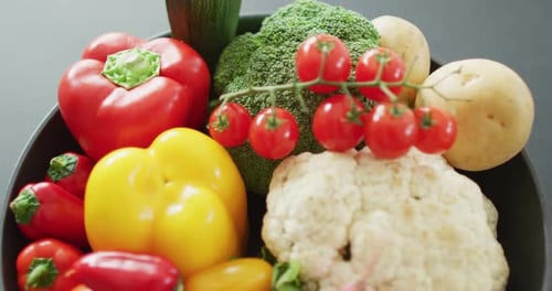 Video of close up of fresh vegetables in pan over grey background