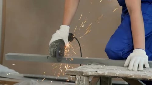 Industrial Worker Cutting Metal with Many Sharp Sparks at Construction Site