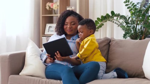 Mother and Child Using Tablet on Couch