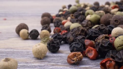 Multi Colored Peppercorns Pile on Gray Table