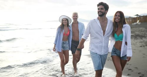 Happy Young Friends Having Fun and Walking at Beach