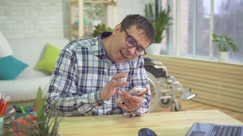 Adult Man Using Smartphone at Desk