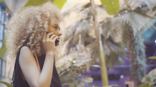 Schöne blonde Frau chattet am Telefon im Restaurant
