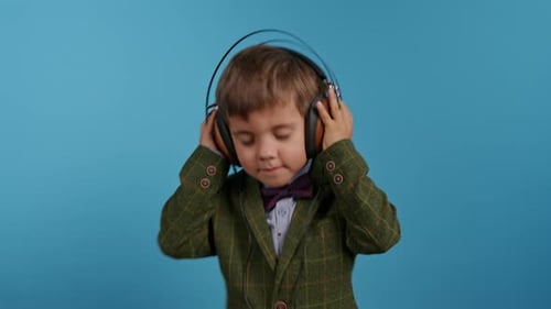 Boy Enjoys Music with Headphones in Studio