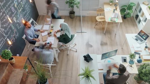Zoomin High Angle View of Creative Team Working in Shared Office Talking Cooperating