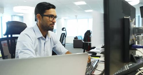 Man Works at Computer in Open Office